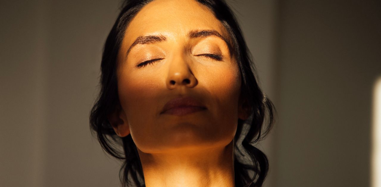 Woman in soft light reflecting strength and healing from cancer without losing identity