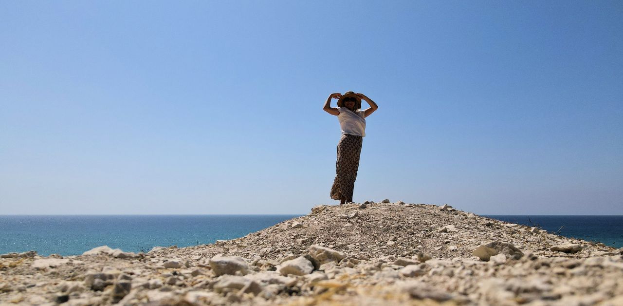 Woman standing in a quiet landscape by the sea, reflecting on what success looks like in real life